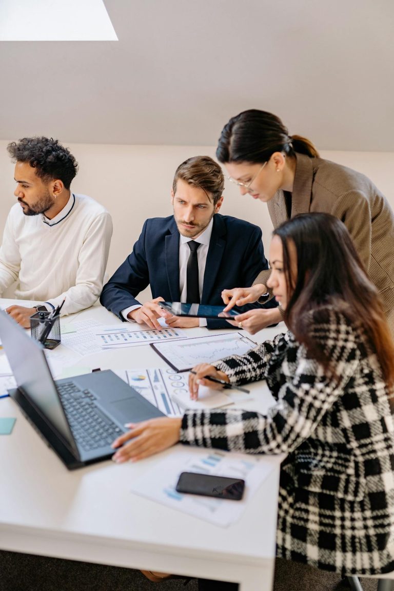 Professionals engaged in a meeting discussing plans in a modern office setting.