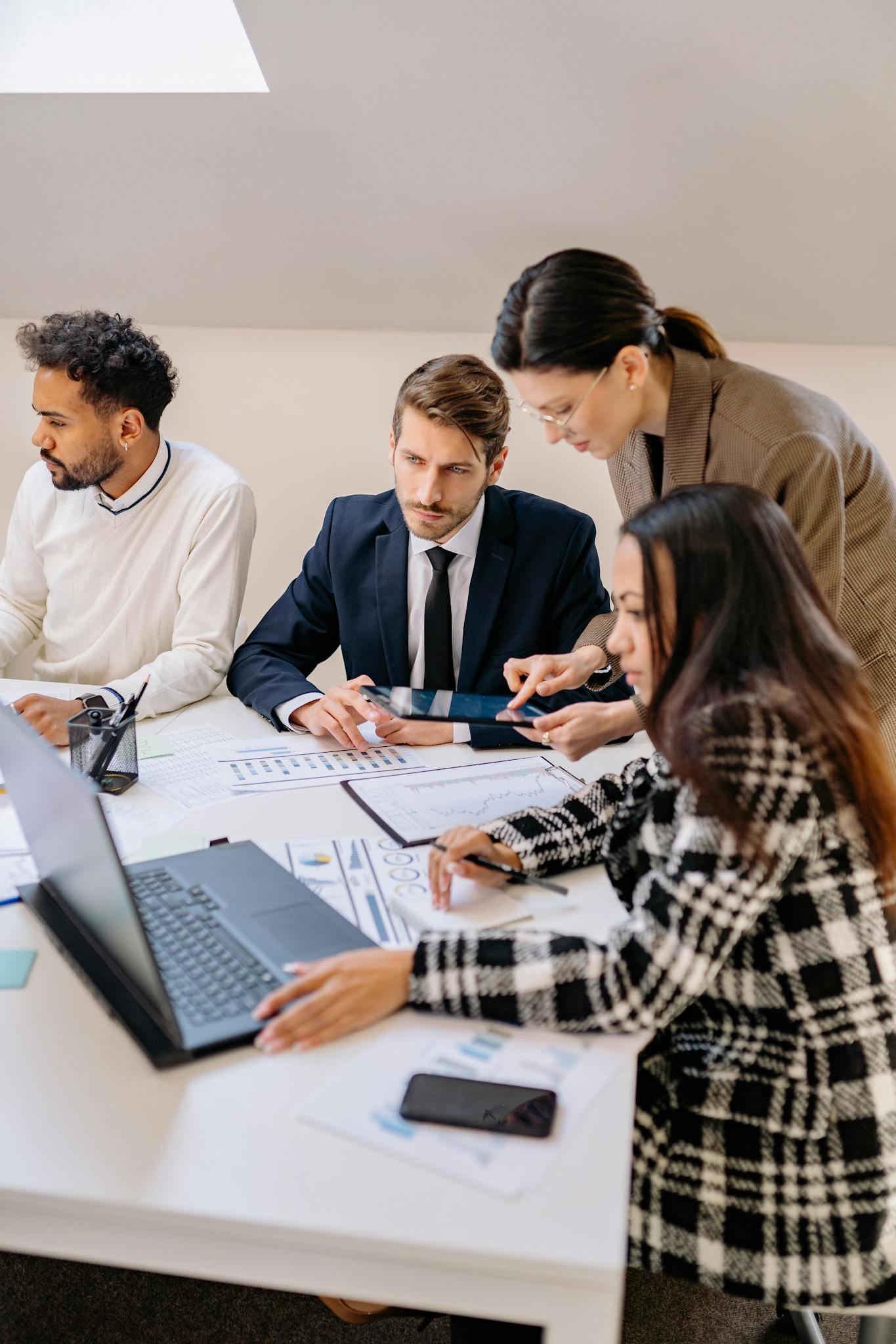 Professionals engaged in a meeting discussing plans in a modern office setting.